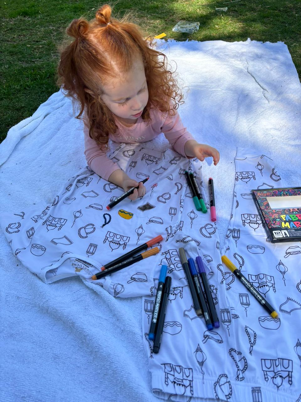 Kids' Ramadan-themed pajamas with color-in prints, paired with non-toxic fabric crayons for a fun and creative gift. 